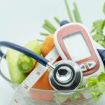11bowl of veggies with glucometer, stethoscope, and tape measure - manage diabetes