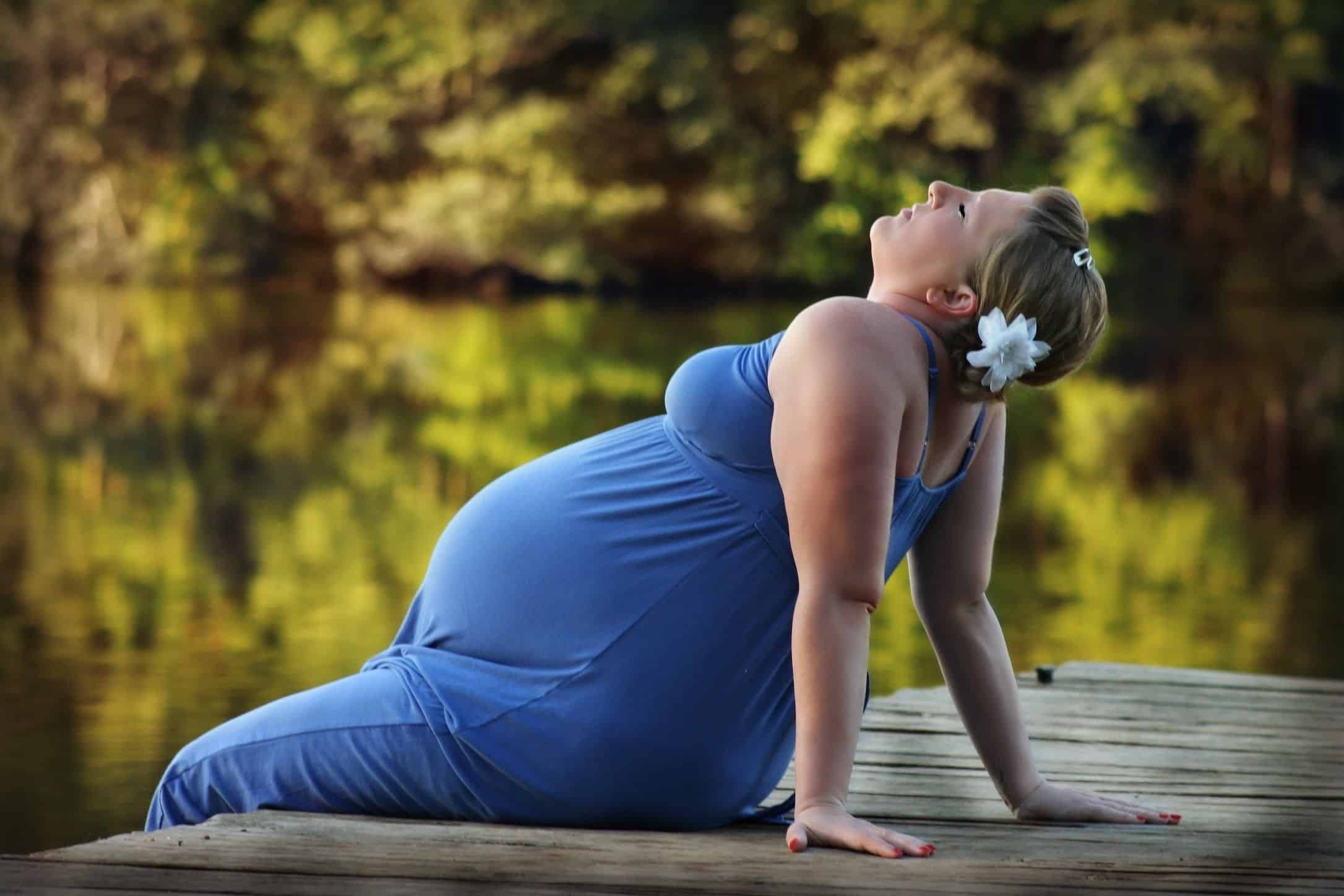 pregnant woman sitting outside enjoying nature