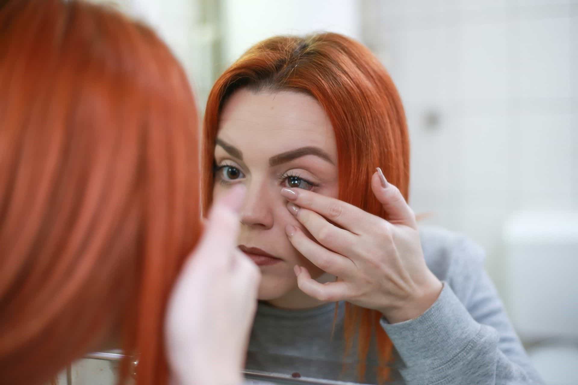 girl putting on contact lens 