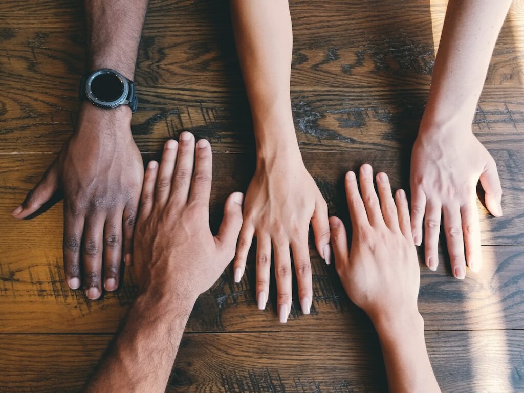 diverse people with hands resting on a table